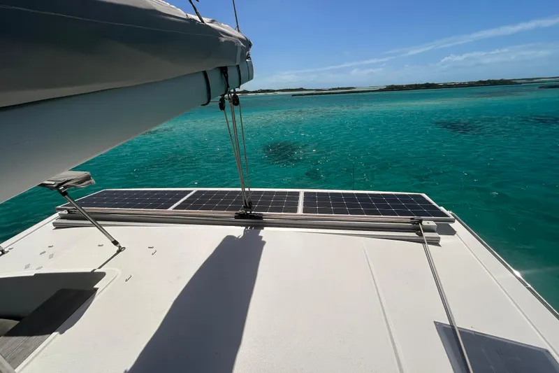 Slide: The Image of Fountaine Pajot Lucia 40 catamaran with solar panels, sailing on clear turquoise waters. - 72