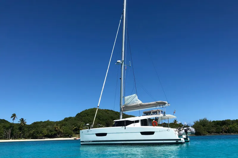 Slide: The Image of 2018 Fountaine Pajot Lucia 40 catamaran anchored in clear blue tropical waters. - 89