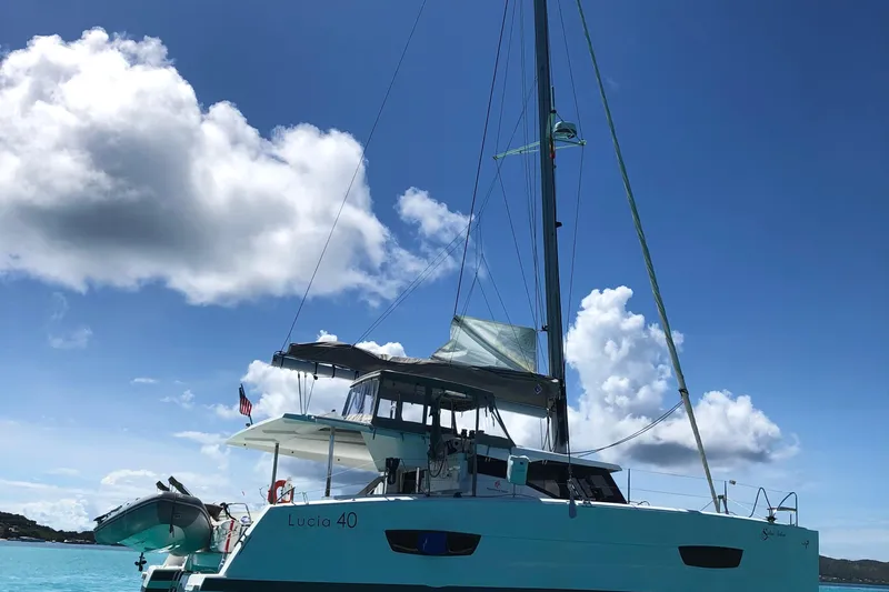 Slide: The Image of 2018 Fountaine Pajot Lucia 40 catamaran sailing under a clear blue sky. - 94