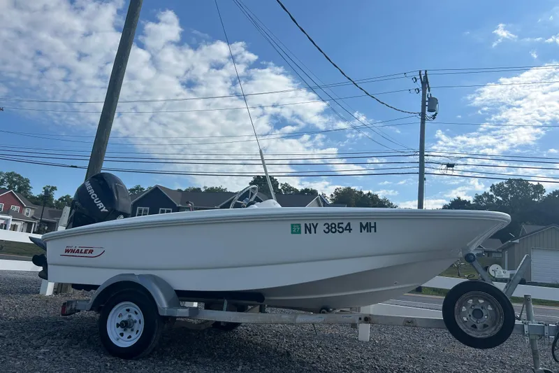 The Image of 2010 Boston Whaler 130 Super Sport boat on trailer under blue sky. - 0