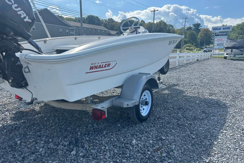 Slide: The Image of 2010 Boston Whaler 130 Super Sport on a trailer, resting on gravel. - 17