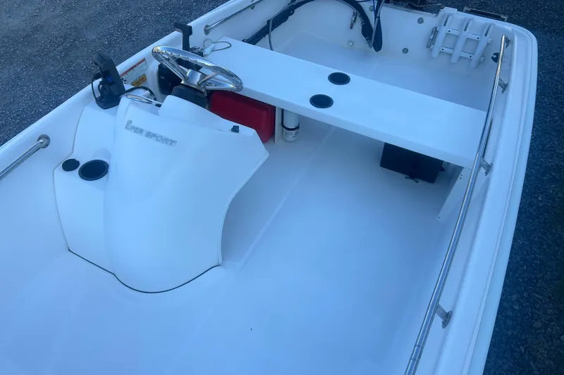 Slide: The Image of 2010 Boston Whaler 130 Super Sport boat with Mercury engine, parked on gravel lot. - 5