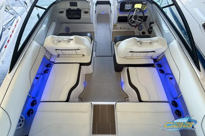 Slide: The Image of 2022 Regal LS2 Surf boat interior with white seating and blue LED lighting. - 12