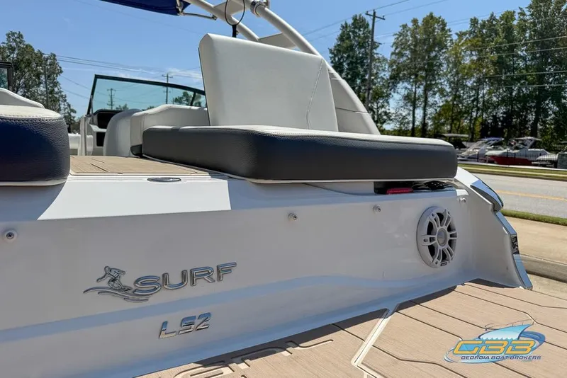 Slide: The Image of 2022 Regal LS2 Surf boat rear view with seating and speaker, parked outdoors. - 29
