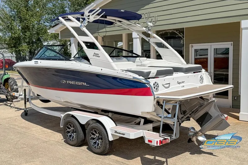 Slide: The Image of 2022 Regal LS2 Surf boat on trailer, displayed outdoors. - 3