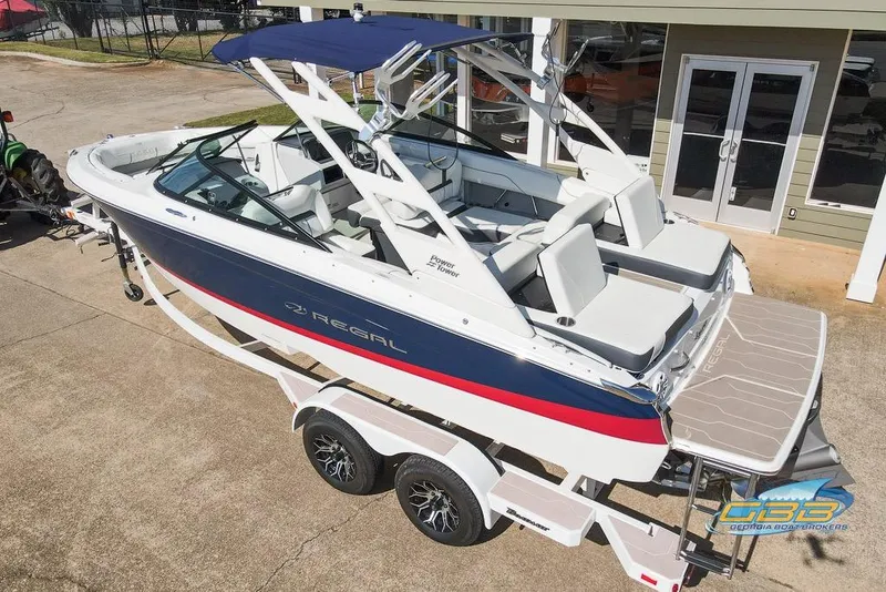 Slide: The Image of 2022 Regal LS2 Surf boat on trailer, featuring sleek design and spacious seating. - 6