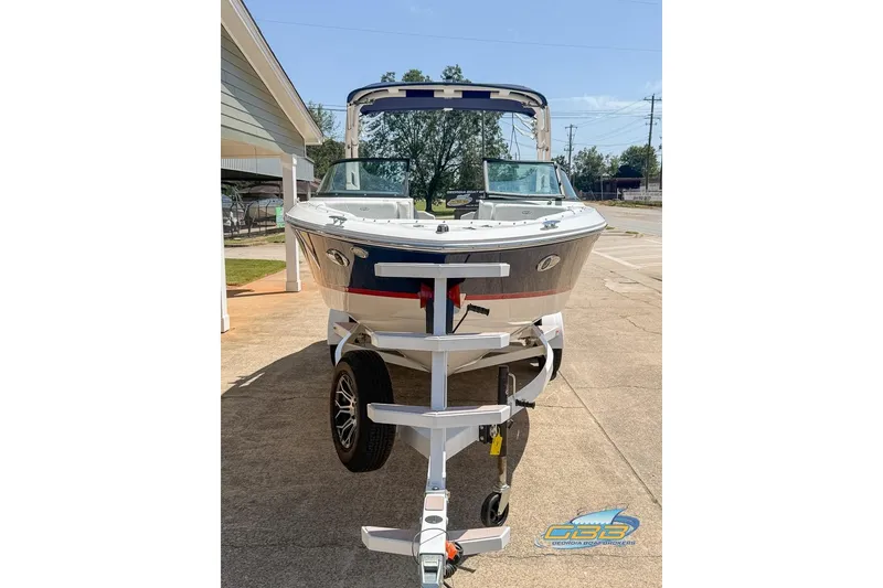 Slide: The Image of 2022 Regal LS2 Surf boat on trailer, parked outdoors. - 7