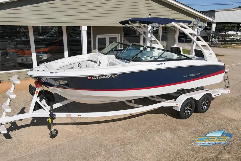 Slide: The Image of 2022 Regal LS2 Surf boat on trailer, parked outside showroom. - 8