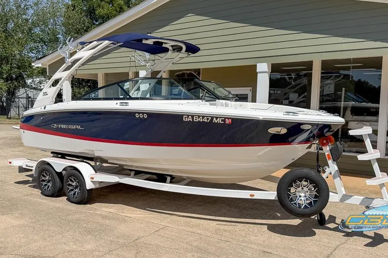 Slide: The Image of 2022 Regal LS2 Surf boat on trailer, parked outside a building. - 9