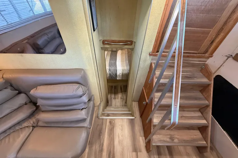 Slide: The Image of 1982 Chris-Craft 410 Motor Yacht interior with stairs, sofa, and cozy cabin. - 10