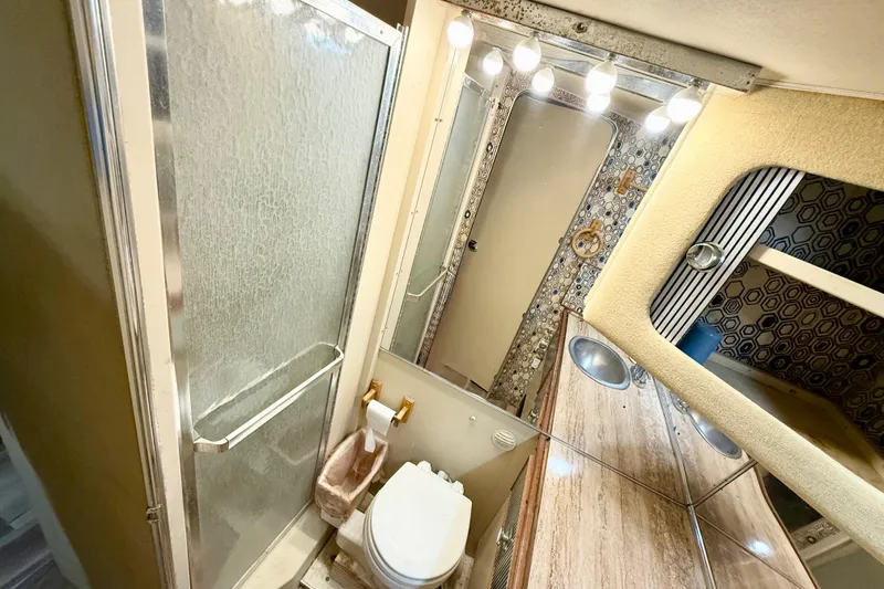 Slide: The Image of 1982 Chris-Craft 410 Motor Yacht bathroom with shower, toilet, and vanity mirror. - 14