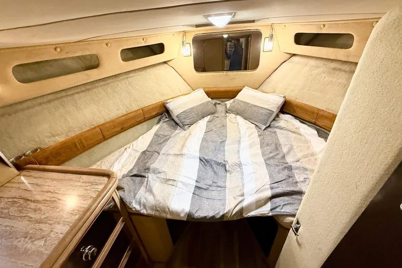 Slide: The Image of 1982 Chris-Craft 410 Motor Yacht cabin with cozy bed and wooden accents. - 15