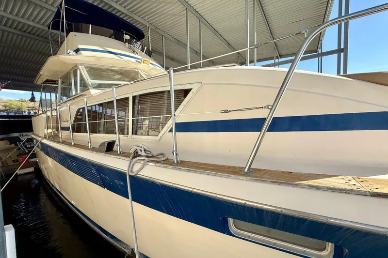 Slide: The Image of 1982 Chris-Craft 410 Motor Yacht docked under a covered marina. - 3