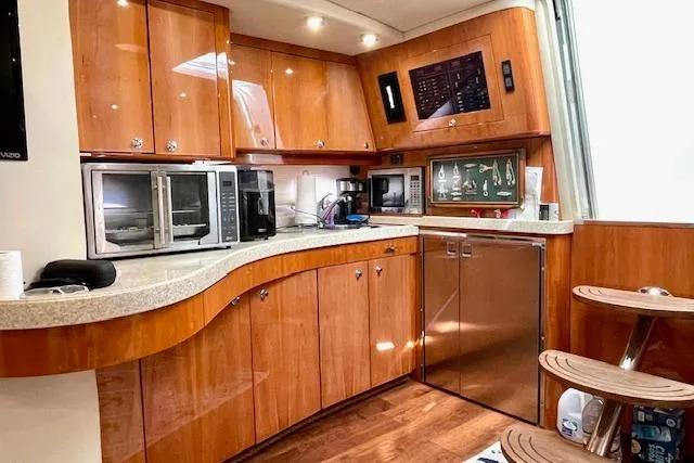 Slide: The Image of Luxurious 2005 Regal Commodore 4260 yacht kitchen with wood cabinetry and modern appliances. - 32