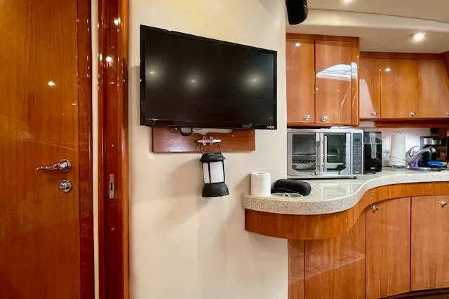 Slide: The Image of Interior of 2005 Regal Commodore 4260 yacht with TV and kitchen appliances. - 33