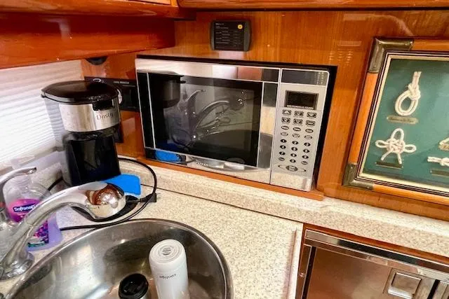 Slide: The Image of 2005 Regal Commodore 4260 yacht kitchen with microwave, coffee maker, and sink. - 36