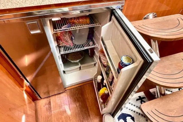 Slide: The Image of Open fridge inside 2005 Regal Commodore 4260 yacht, stocked with food and beverages. - 37