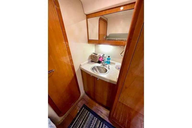 Slide: The Image of 2005 Regal Commodore 4260 yacht bathroom with wooden cabinetry and compact sink. - 45