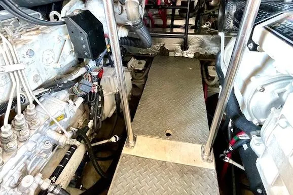 Slide: The Image of Engine room of 2005 Regal Commodore 4260 yacht, showcasing mechanical components and walkway. - 52