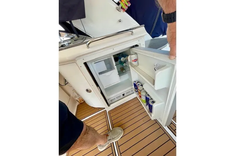 Slide: The Image of Open mini fridge on 2005 Regal Commodore 4260 boat, stocked with drinks on teak flooring. - 9