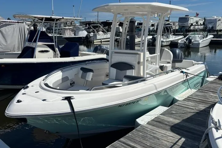 Slide: The Image of 2020 Robalo R222 Center Console boat docked at a marina under clear skies. - 1