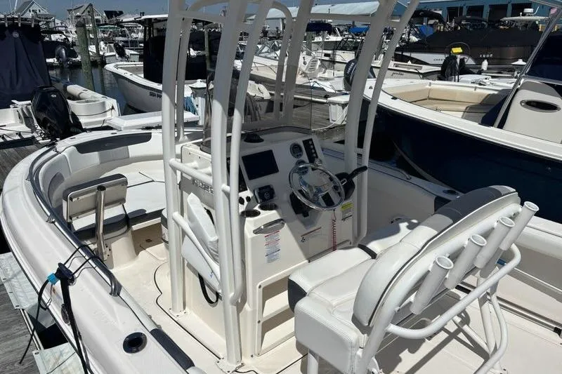 Slide: The Image of 2020 Robalo R222 Center Console boat at marina, featuring helm and seating area. - 10