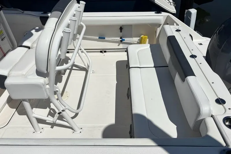 Slide: The Image of 2020 Robalo R222 Center Console boat interior with white seating and rod holders. - 11
