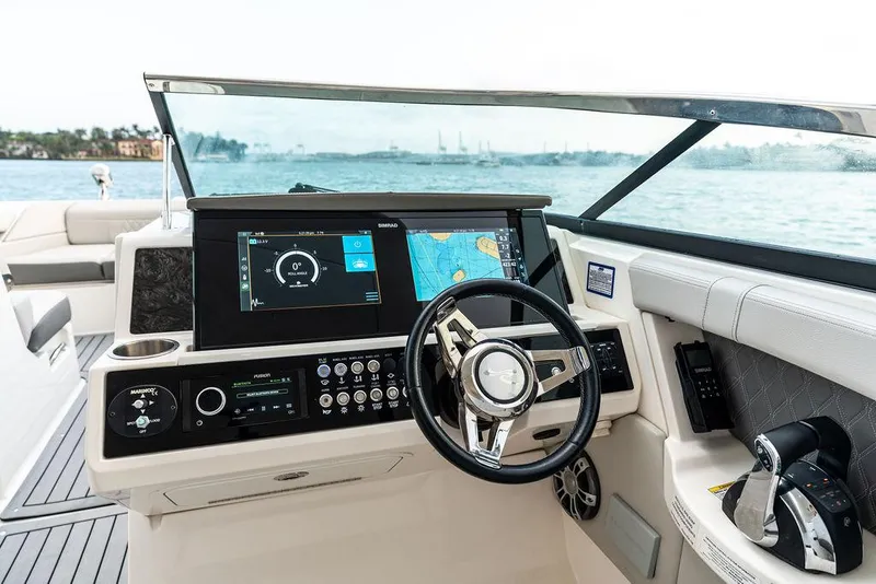 Slide: The Image of 2021 Sea Ray 350 SLX OB boat dashboard with navigation screens and steering wheel. - 16