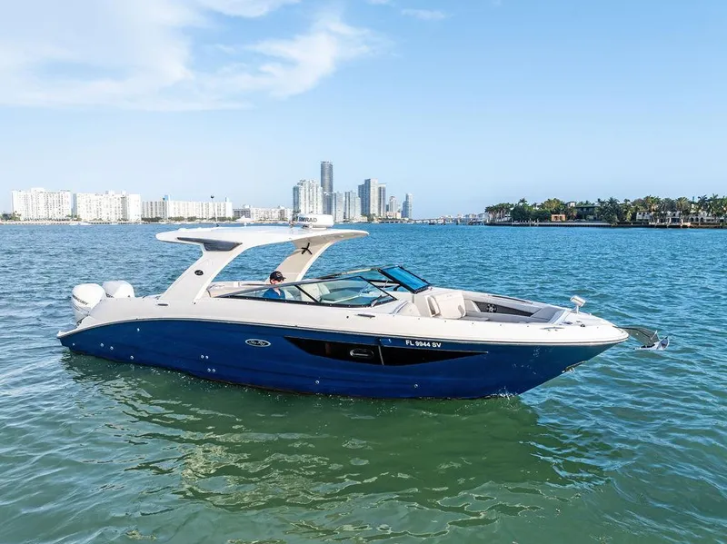 Slide: The Image of 2021 Sea Ray 350 SLX OB boat cruising on a sunny day with city skyline backdrop. - 35