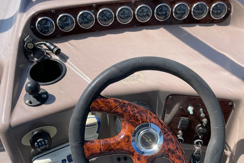 Slide: The Image of Steering wheel and dashboard of a 2003 Regal Commodore 3060 boat with gauges and controls. - 11