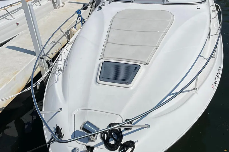 Slide: The Image of 2003 Regal Commodore 3060 boat docked, featuring sleek white design and deck details. - 3