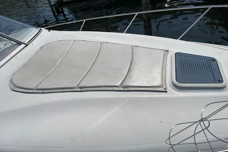 Slide: The Image of 2003 Regal Commodore 3060 boat deck with sunpad and hatch, docked by the water. - 4