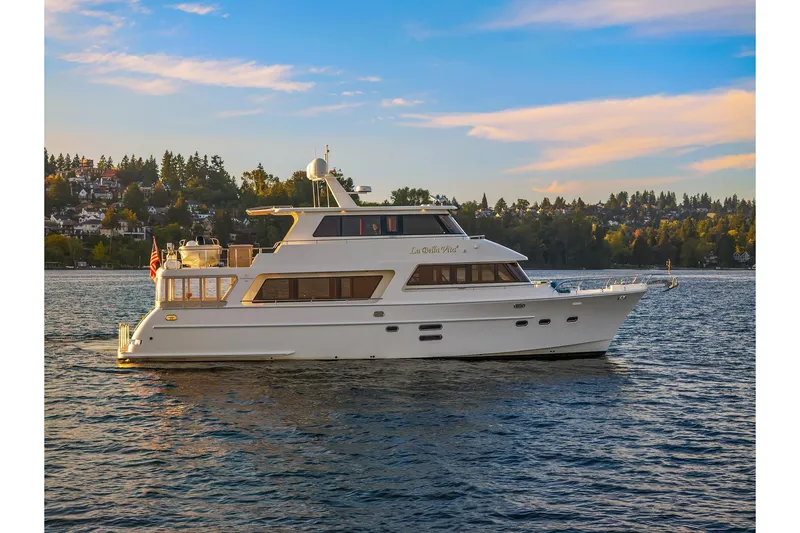 The Image of 2014 Hampton 720 Skylounge LRC yacht cruising on a scenic lake at sunset. - 0