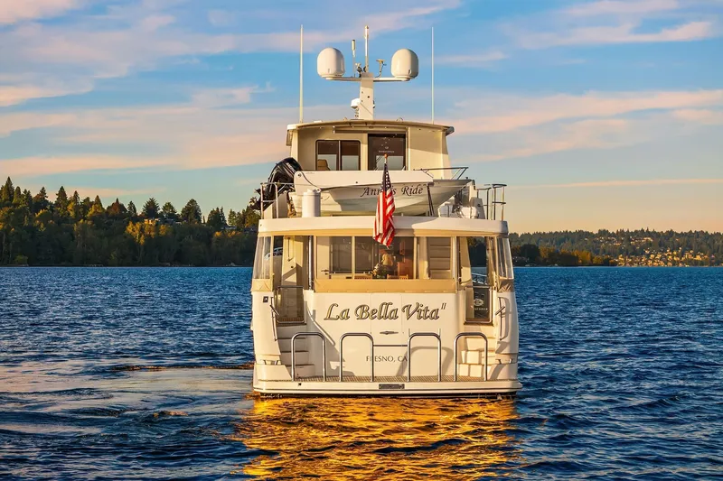 Slide: The Image of 2014 Hampton 720 Skylounge LRC yacht cruising at sunset on calm waters. - 112