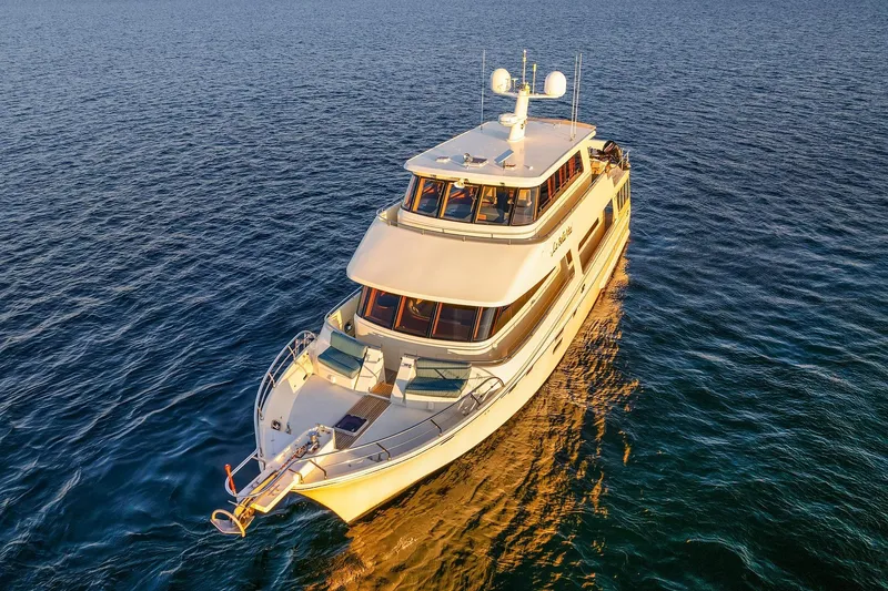 Slide: The Image of Luxurious 2014 Hampton 720 Skylounge LRC yacht cruising at sunset on open water. - 121