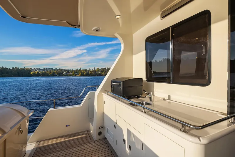 Slide: The Image of 2014 Hampton 720 Skylounge LRC yacht with Mercury engine at sunset on serene water. - 63