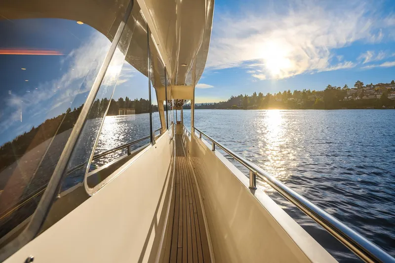 Slide: The Image of 2014 Hampton 720 Skylounge LRC yacht cruising at sunset on open water. - 83