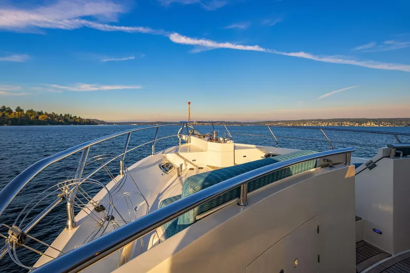 Slide: The Image of Bow view of 2014 Hampton 720 Skylounge LRC yacht on serene water under blue sky. - 88