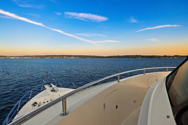 Slide: The Image of 2014 Hampton 720 Skylounge LRC yacht cruising on serene waters at sunset. - 89