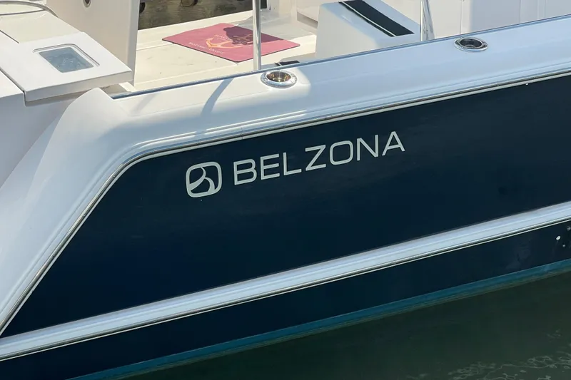 Slide: The Image of 2017 Belzona 325 Center Console boat on calm water, featuring sleek design and spacious deck. - 16