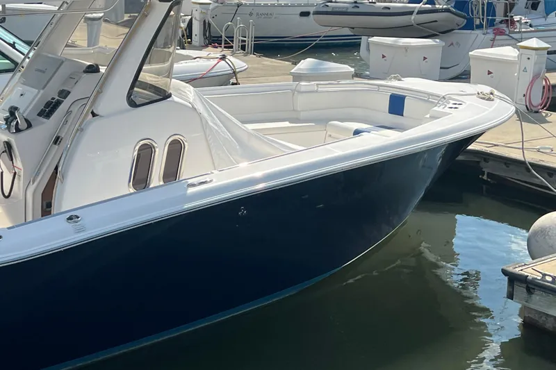 Slide: The Image of 2017 Belzona 325 Center Console boat cruising on a calm lake under a clear sky. - 17