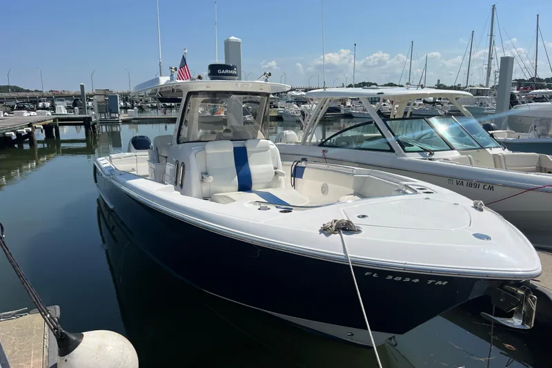 Slide: The Image of 2017 Belzona 325 Center Console boat docked at a marina under clear skies. - 25