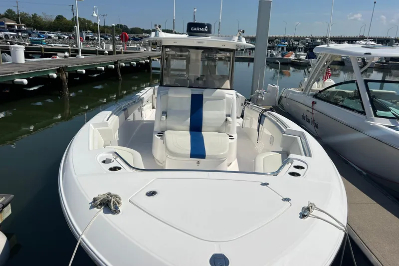 Slide: The Image of 2017 Belzona 325 Center Console boat docked at marina, featuring sleek design and spacious seating. - 27