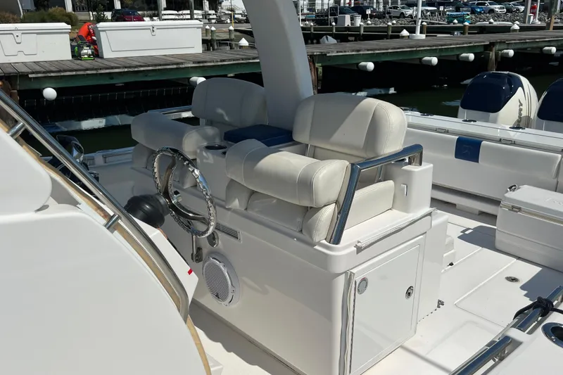 Slide: The Image of 2017 Belzona 325 Center Console boat interior with white seating and steering wheel. - 30