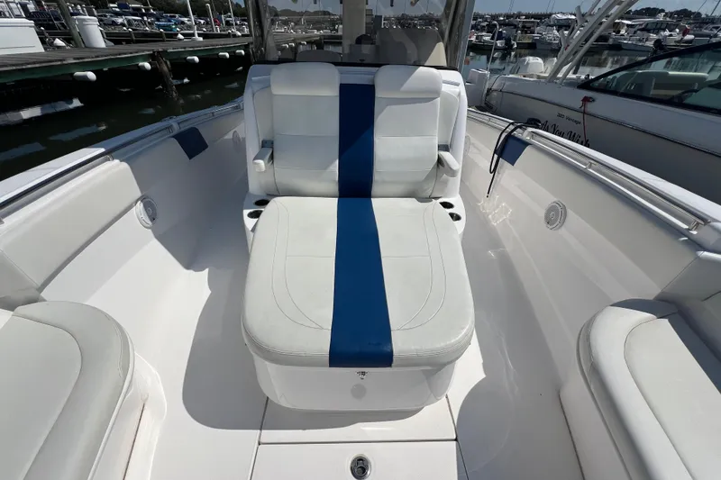 Slide: The Image of 2017 Belzona 325 Center Console boat with white and blue seating at a marina. - 39