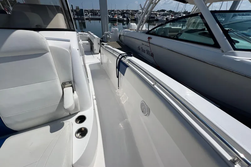 Slide: The Image of 2017 Belzona 325 Center Console boat interior with white seating and marina view. - 40