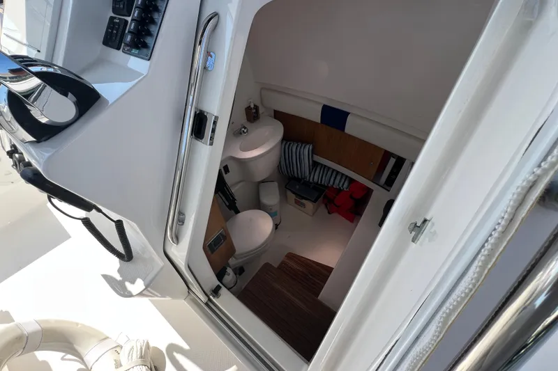 Slide: The Image of Interior cabin of 2017 Belzona 325 Center Console boat, featuring a compact bathroom. - 43