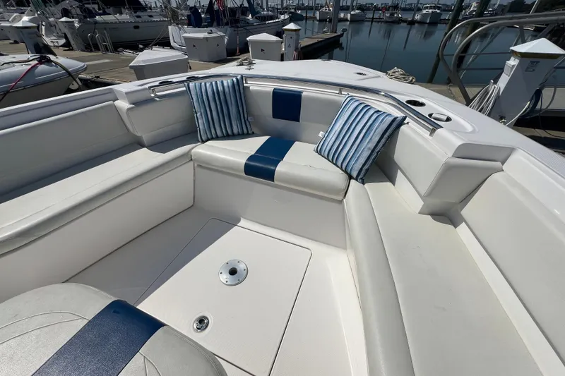 Slide: The Image of 2017 Belzona 325 Center Console boat interior with striped cushions at a marina. - 44
