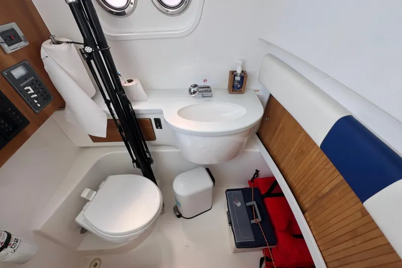 Slide: The Image of 2017 Belzona 325 Center Console boat bathroom with sink, toilet, and storage. - 49