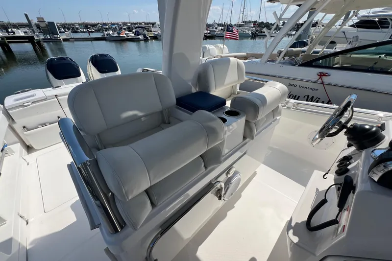 Slide: The Image of 2017 Belzona 325 Center Console boat interior with helm and seating at marina. - 50